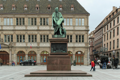 Strasbourg, place Gutenberg. Statue de Gutenberg, bronze, David d'Angers, 1839. Guttenberg, debout près d'une presse d'imprimerie tient un parchemin sur lequel on lit « et la lumière fut » ; le piédestal est agrémenté de quatre reliefs.